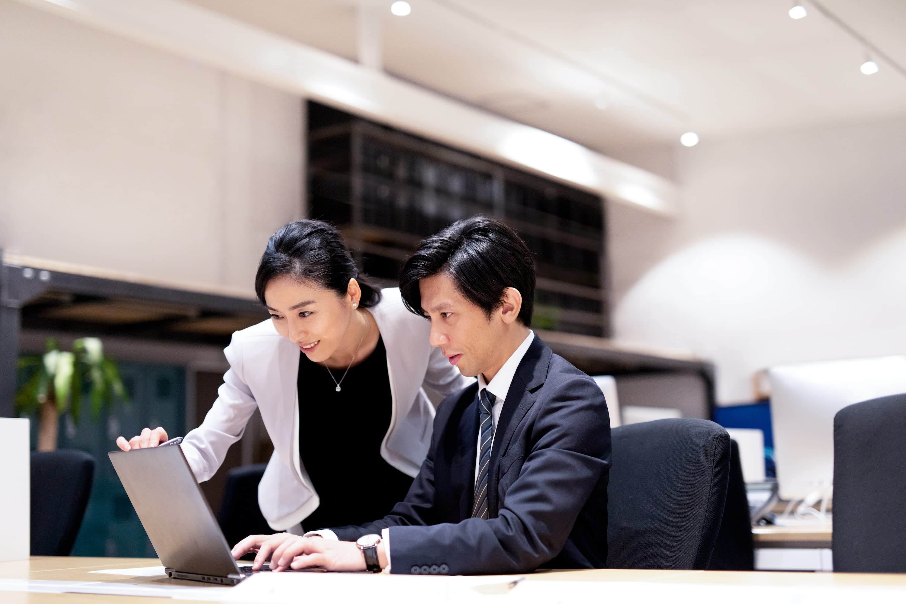 2人の同僚がモダンなオフィスで活発な議論をしています。