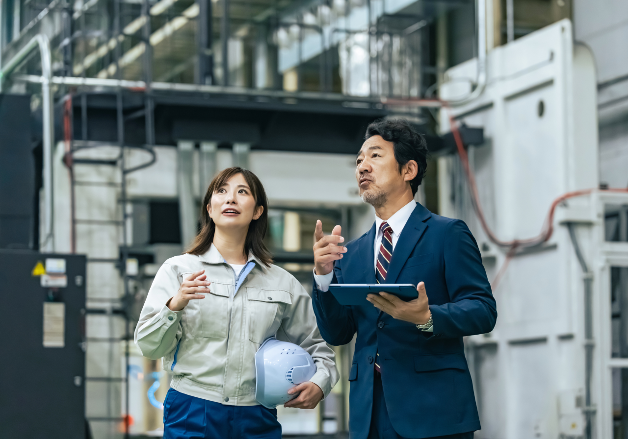 製造にたずさわる従業員とロボットアーム